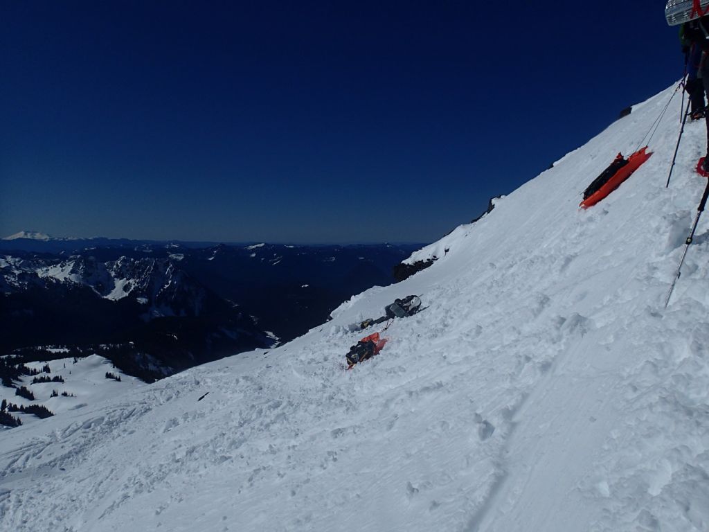 A climber being dragged down the mountain by his sled